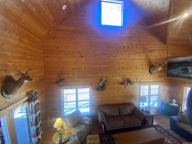 unfurnished living room featuring high vaulted ceiling, wooden ceiling, wood walls, and plenty of natural light