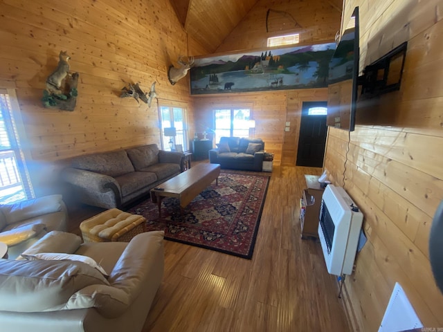 living room featuring wood ceiling, hardwood / wood-style floors, heating unit, wooden walls, and high vaulted ceiling