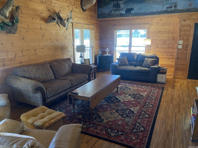 living room featuring a healthy amount of sunlight, hardwood / wood-style floors, and wooden walls