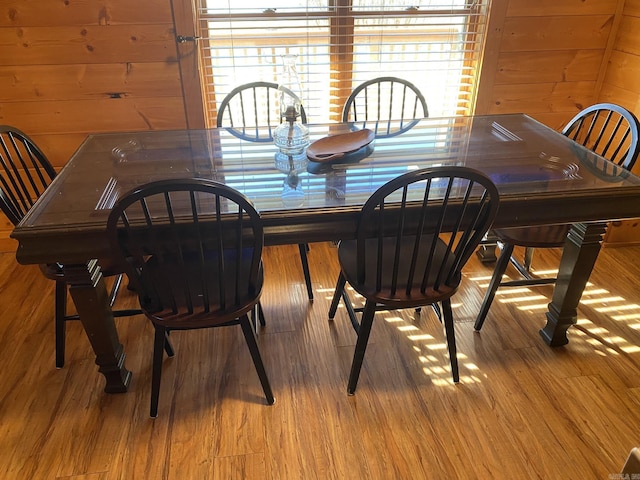 dining space featuring wooden walls and light hardwood / wood-style floors