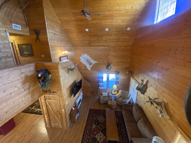 living room with light hardwood / wood-style flooring, wooden ceiling, and wood walls