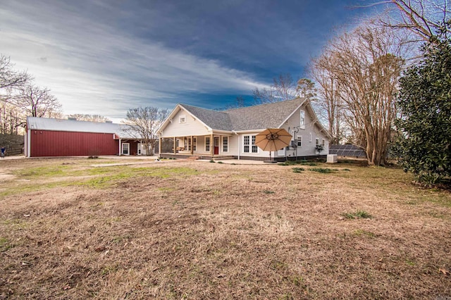 view of front of property with a porch, a front lawn, and an outbuilding