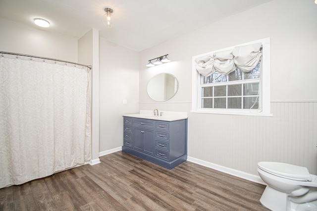 bathroom with toilet, vanity, and hardwood / wood-style flooring