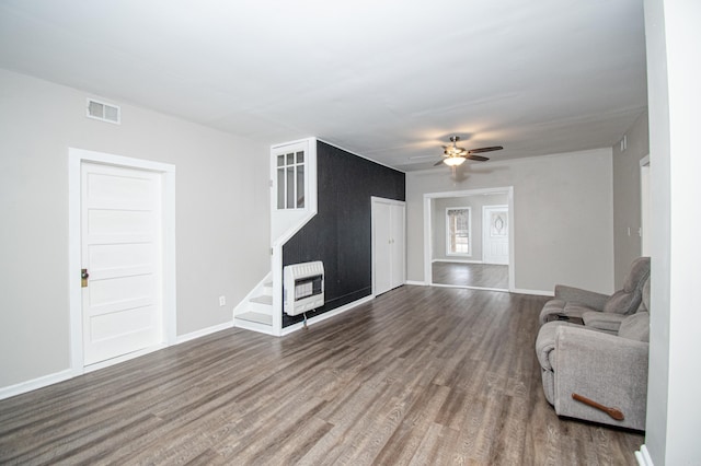 unfurnished living room with ceiling fan, heating unit, and wood-type flooring