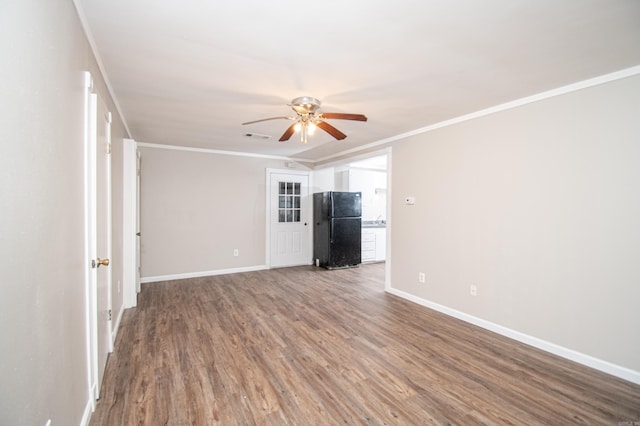 empty room with ceiling fan, crown molding, and wood-type flooring