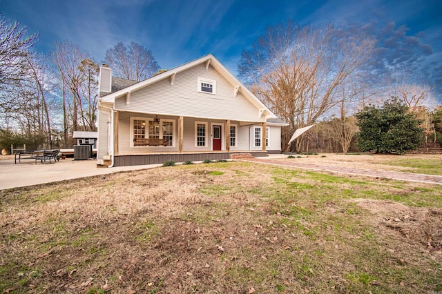 view of front of property featuring covered porch, a front lawn, a patio area, and central AC unit