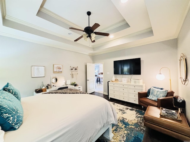 bedroom with ornamental molding, ceiling fan, a tray ceiling, and dark hardwood / wood-style flooring