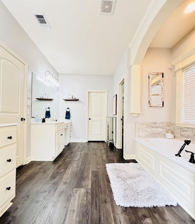 bathroom featuring a bath, vanity, and wood-type flooring