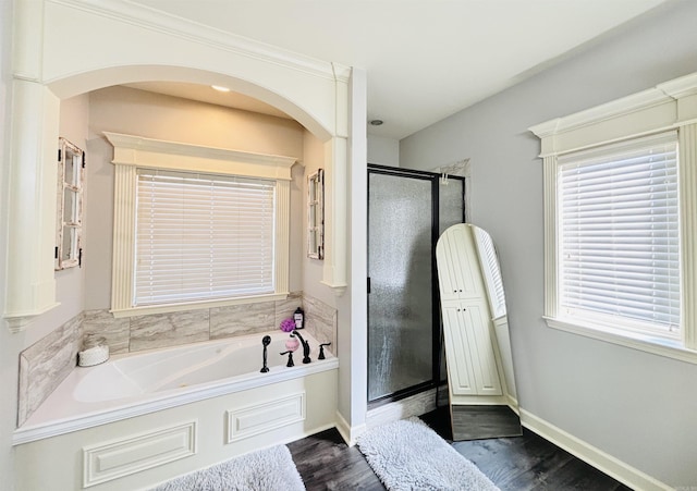 bathroom with hardwood / wood-style floors and independent shower and bath