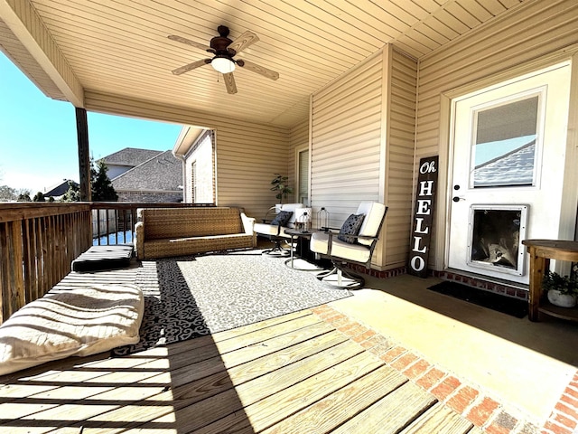 deck with ceiling fan, a patio area, and outdoor lounge area