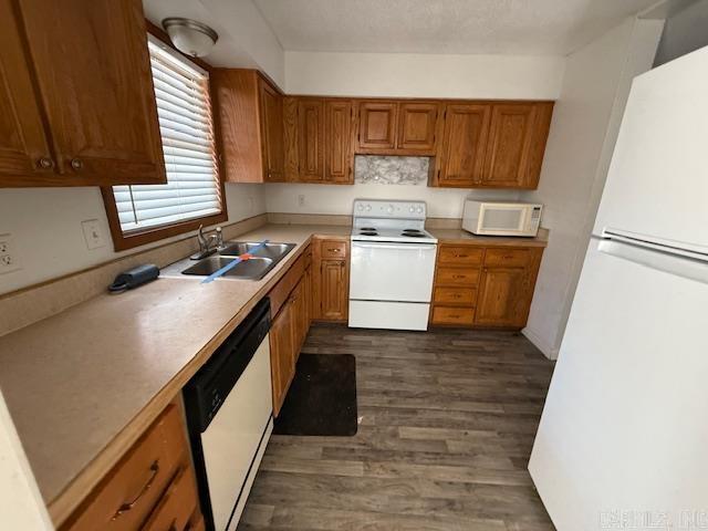 kitchen featuring sink, white appliances, and dark wood-type flooring