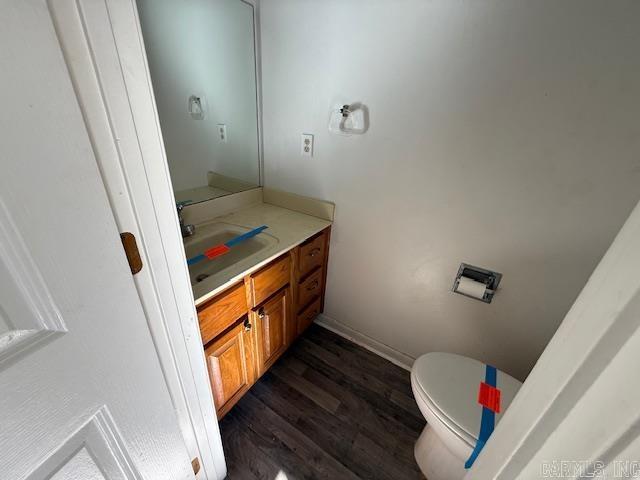 bathroom featuring toilet, vanity, and hardwood / wood-style floors