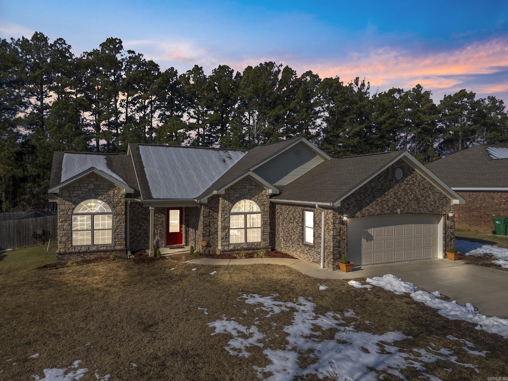 single story home featuring a garage and a yard