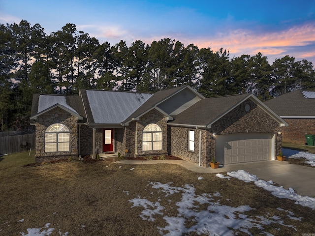 single story home featuring a garage and a yard