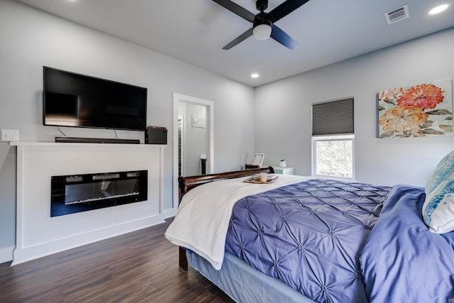 bedroom featuring ceiling fan, dark hardwood / wood-style flooring, and ensuite bath