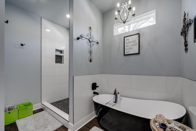 bathroom with tile walls, a chandelier, independent shower and bath, and hardwood / wood-style floors