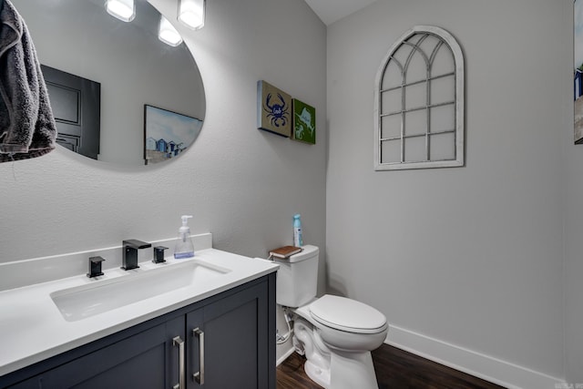 bathroom featuring wood-type flooring, vanity, and toilet