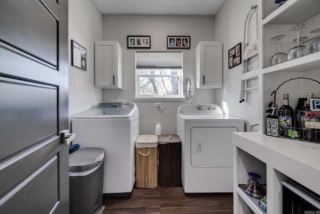 washroom with dark wood-type flooring, cabinets, and independent washer and dryer