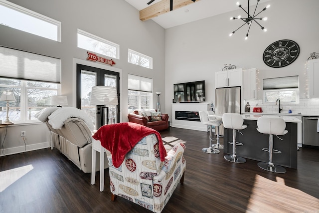 living room with a high ceiling, beam ceiling, and dark hardwood / wood-style floors