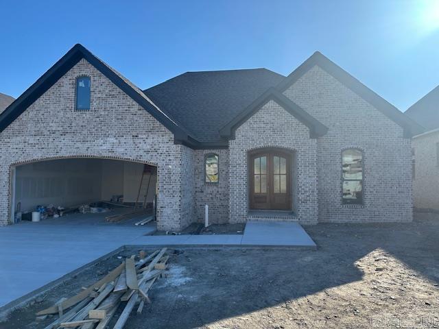 french country inspired facade featuring french doors and a garage