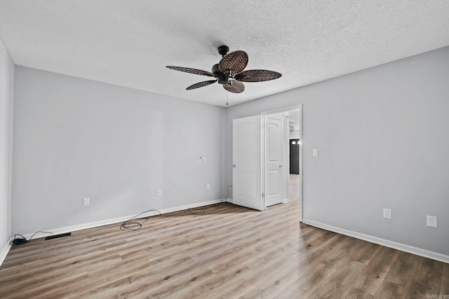 empty room with a textured ceiling, ceiling fan, and light hardwood / wood-style flooring