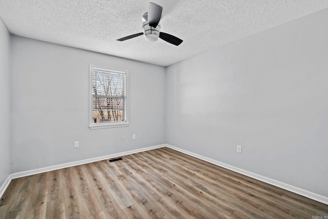 unfurnished room with a textured ceiling, ceiling fan, and wood-type flooring