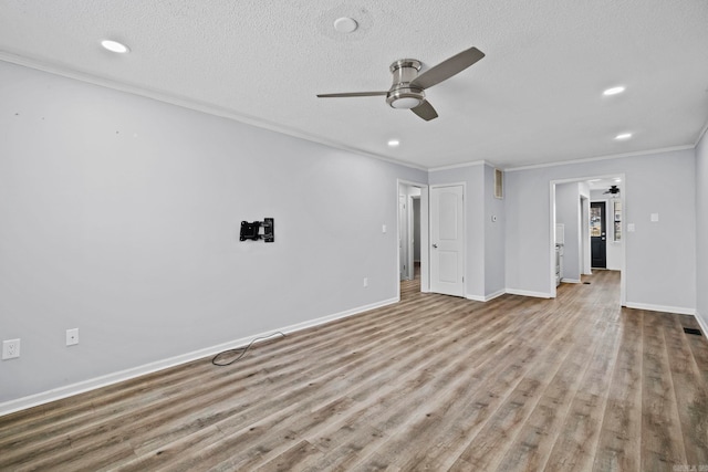 unfurnished living room featuring a textured ceiling, ceiling fan, and ornamental molding