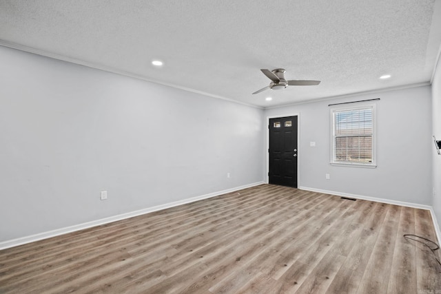 unfurnished room featuring light hardwood / wood-style floors, ceiling fan, crown molding, and a textured ceiling