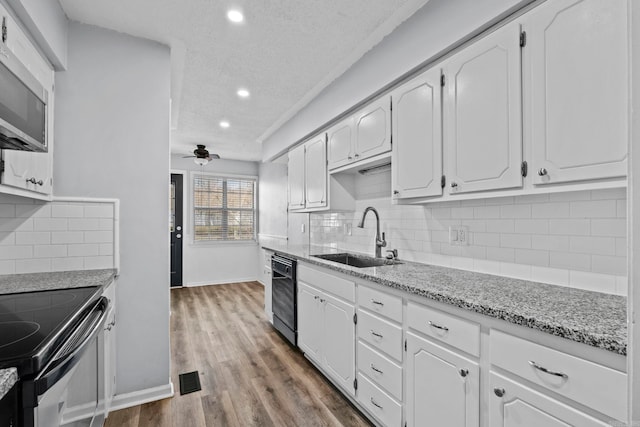 kitchen featuring white cabinets, ceiling fan, black appliances, and sink