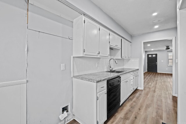 kitchen featuring tasteful backsplash, white cabinets, ceiling fan, black dishwasher, and sink