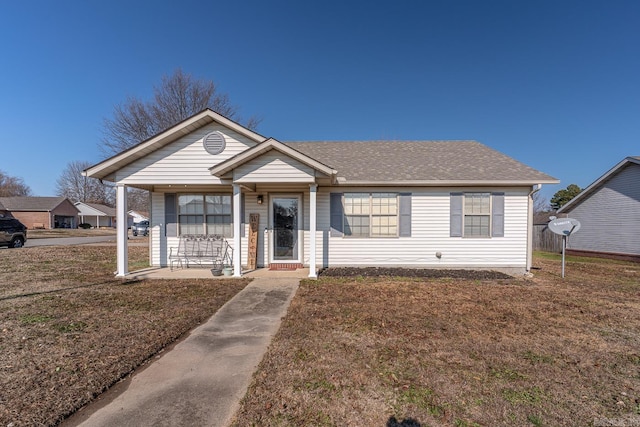 ranch-style house featuring covered porch and a front lawn