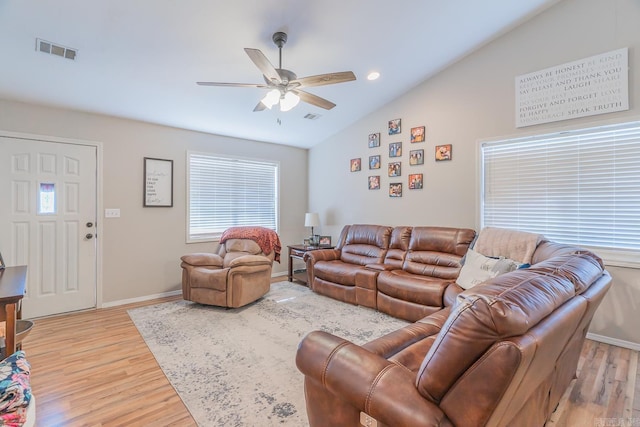 living room with ceiling fan, light hardwood / wood-style flooring, and vaulted ceiling