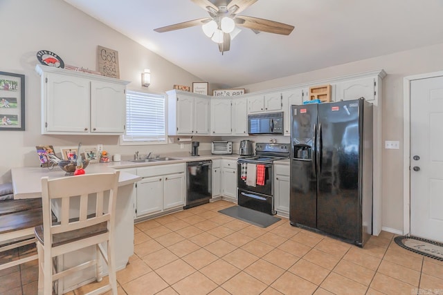 kitchen with sink, white cabinetry, lofted ceiling, light tile patterned flooring, and black appliances