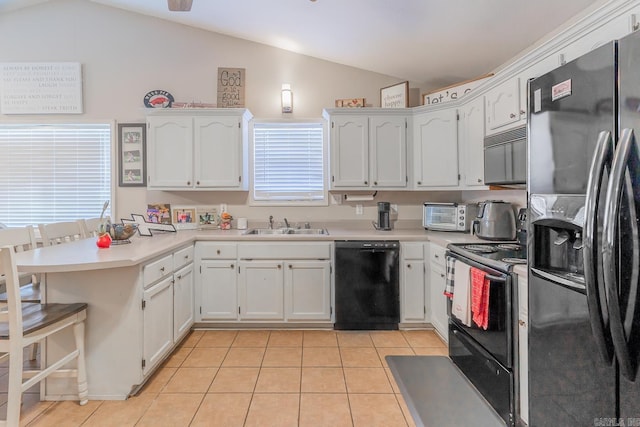 kitchen featuring vaulted ceiling, white cabinets, and black appliances