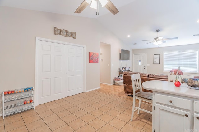 kitchen featuring lofted ceiling, light tile patterned flooring, white cabinetry, and ceiling fan