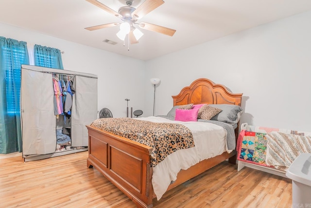 bedroom with a closet, ceiling fan, and light wood-type flooring