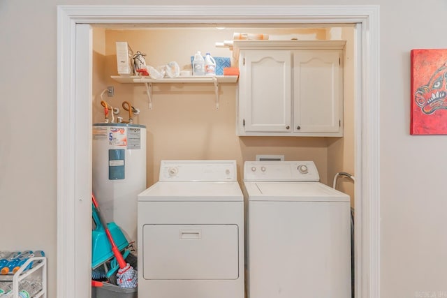 laundry area with washer and dryer, electric water heater, and cabinets