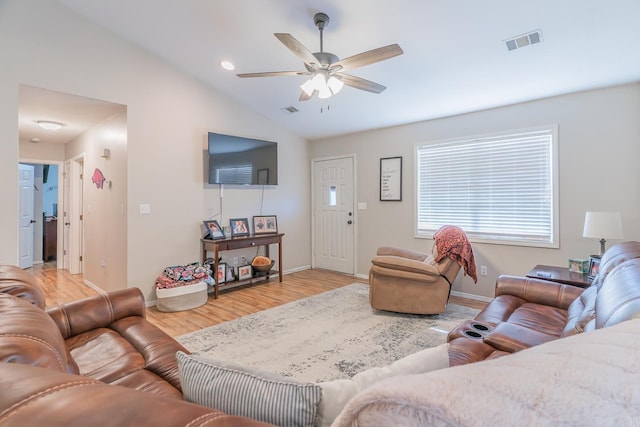 living room with ceiling fan, vaulted ceiling, and light wood-type flooring