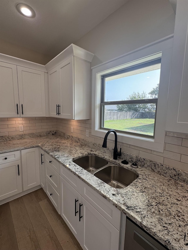 kitchen with white cabinets, light hardwood / wood-style flooring, and sink