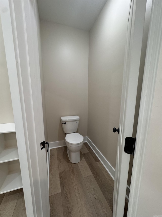 bathroom with toilet and hardwood / wood-style flooring