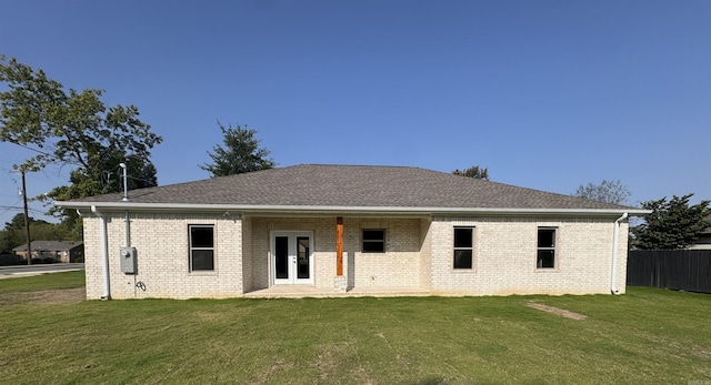 rear view of property featuring french doors and a lawn