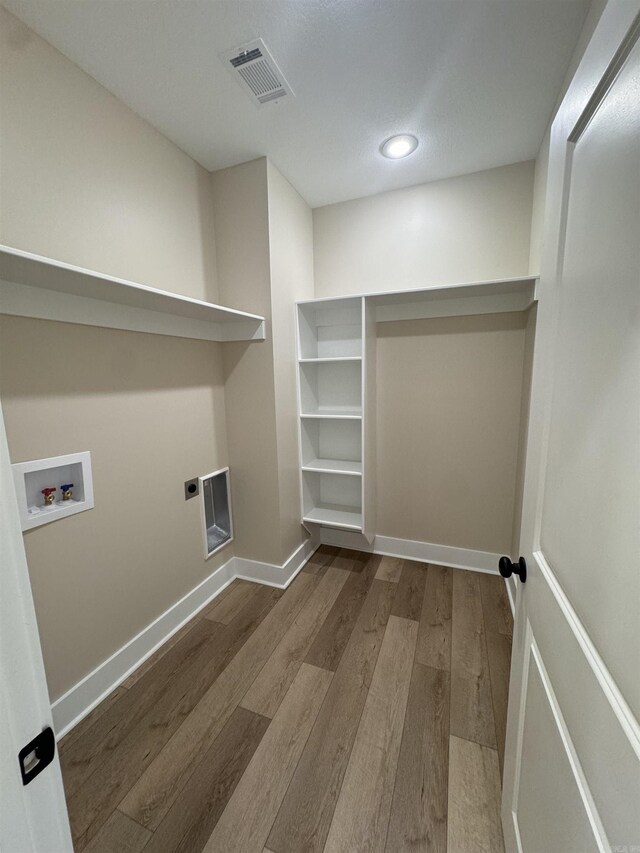 washroom featuring electric dryer hookup, hardwood / wood-style floors, and hookup for a washing machine