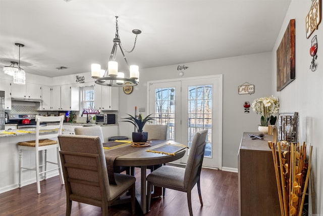 dining space with a notable chandelier and dark hardwood / wood-style floors