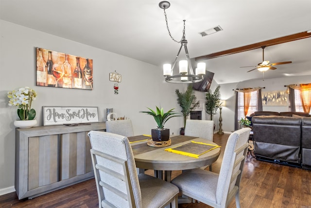 dining space with dark wood-type flooring, lofted ceiling with beams, and ceiling fan with notable chandelier