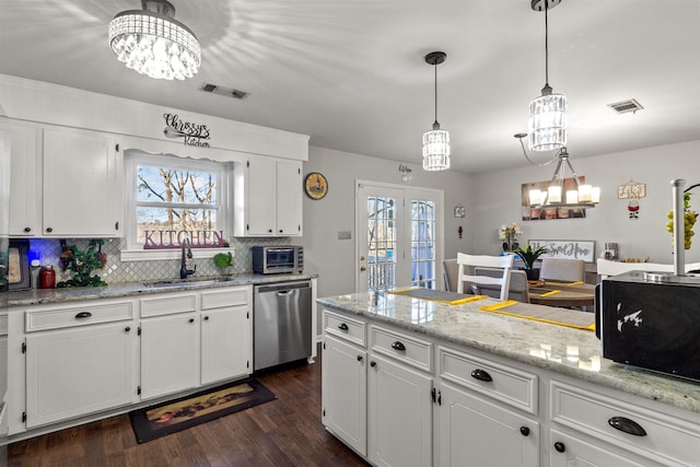 kitchen with stainless steel dishwasher, white cabinetry, pendant lighting, and sink