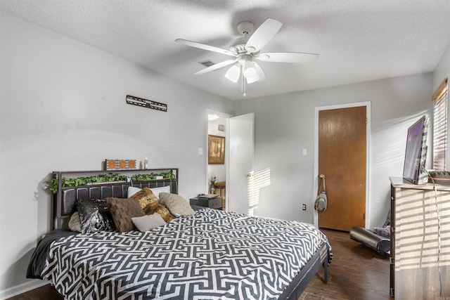 bedroom with a textured ceiling, ceiling fan, and dark hardwood / wood-style flooring