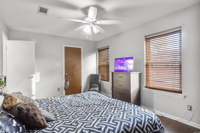 bedroom featuring ceiling fan, hardwood / wood-style floors, and a textured ceiling