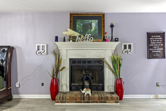 living room featuring a brick fireplace and hardwood / wood-style flooring