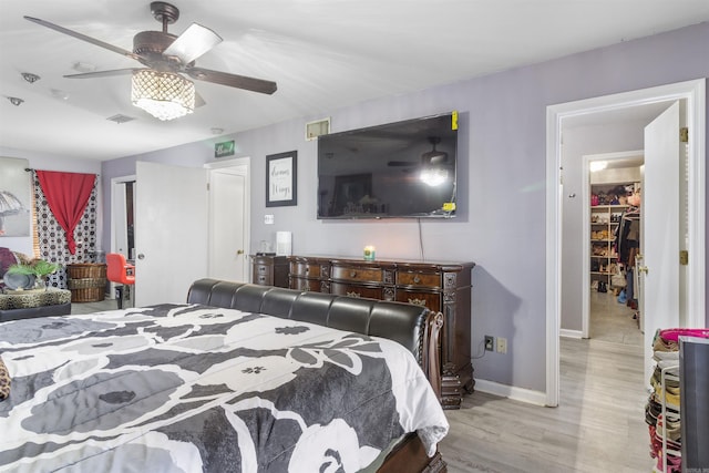 bedroom with light wood-type flooring, ceiling fan, and a closet