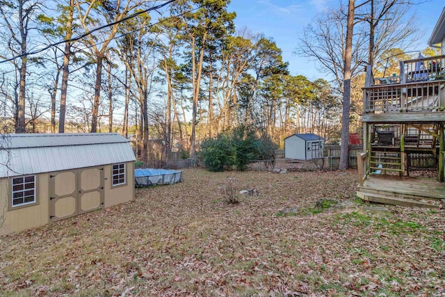 view of yard featuring a swimming pool side deck and a storage shed